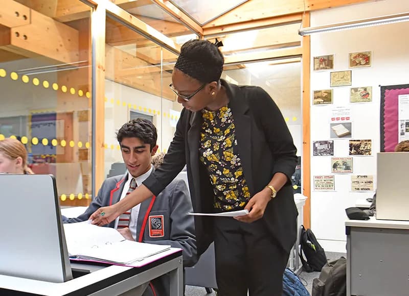 A teacher looking through a folder with a student