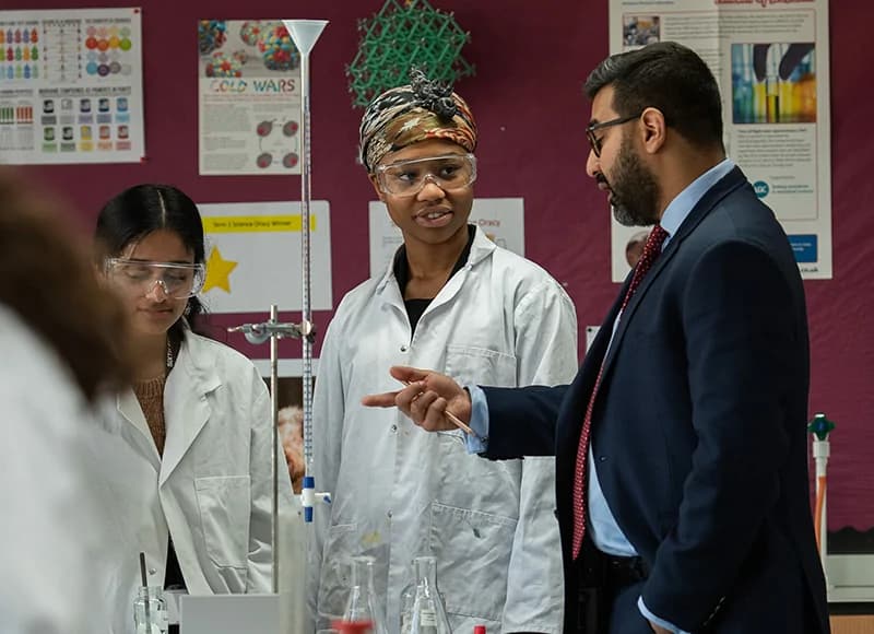 A leader talking to students in a science classroom